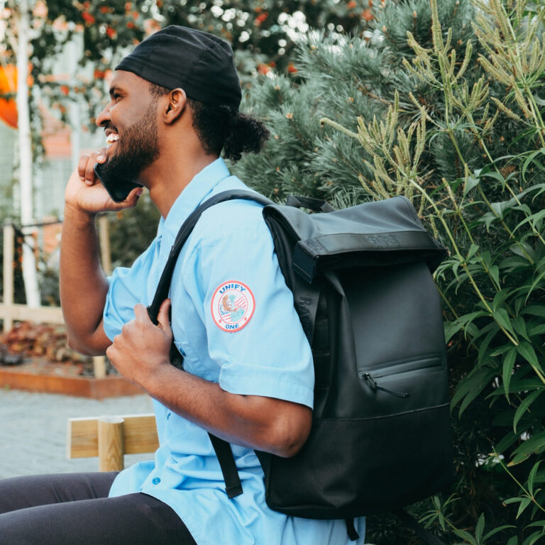 Treningsbag foran en mann som trener sittende på gulvet. I hendene har mannen en medisinball